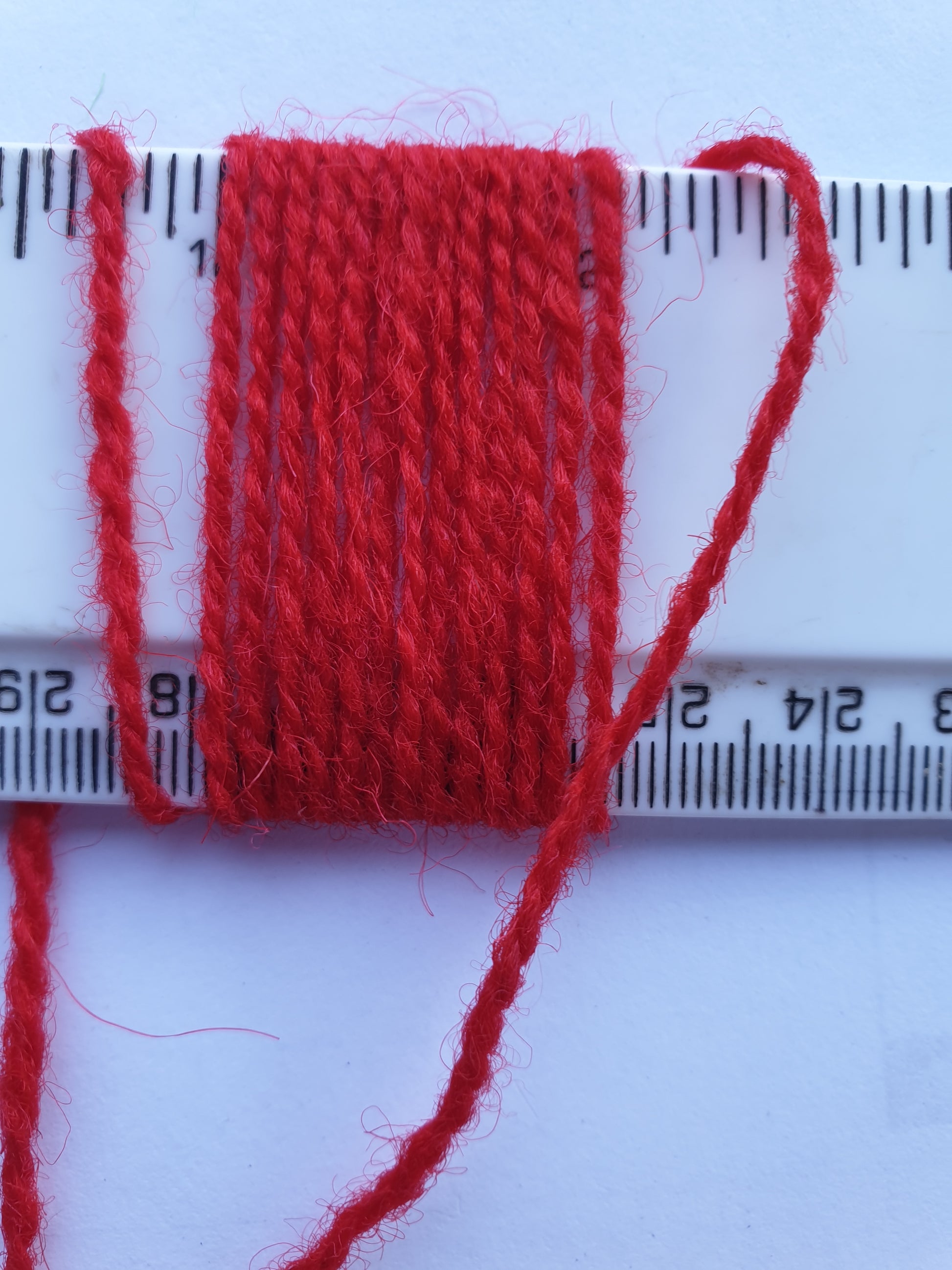 Red Rug Yarn showing wraps per inch