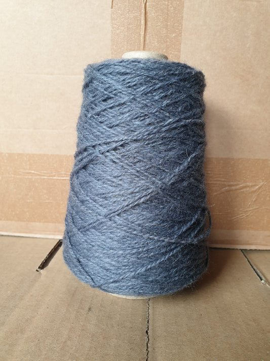 A greyish blue cone of rug yarn