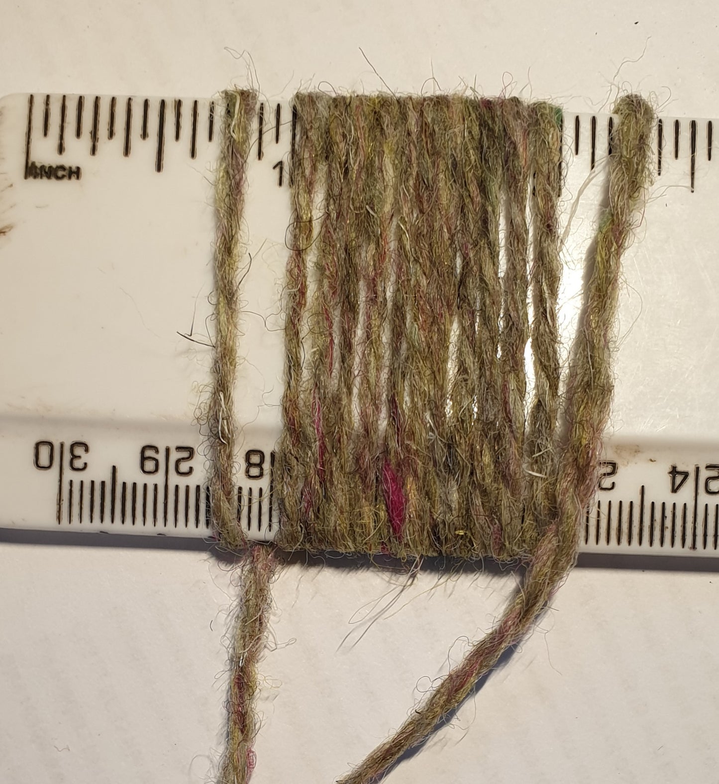 Tweedy green rug yarn showing wraps per inch