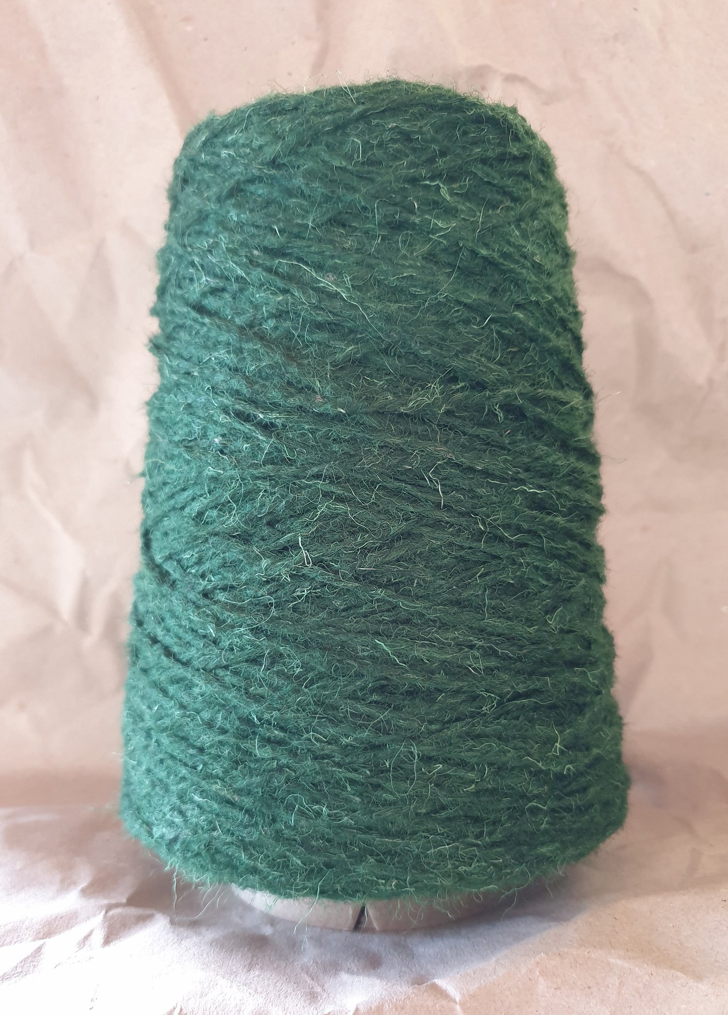 A 250g cone of tough bottle green wool yarn