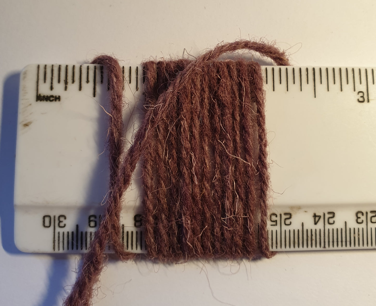 Mauve rug wool showing wraps per inch