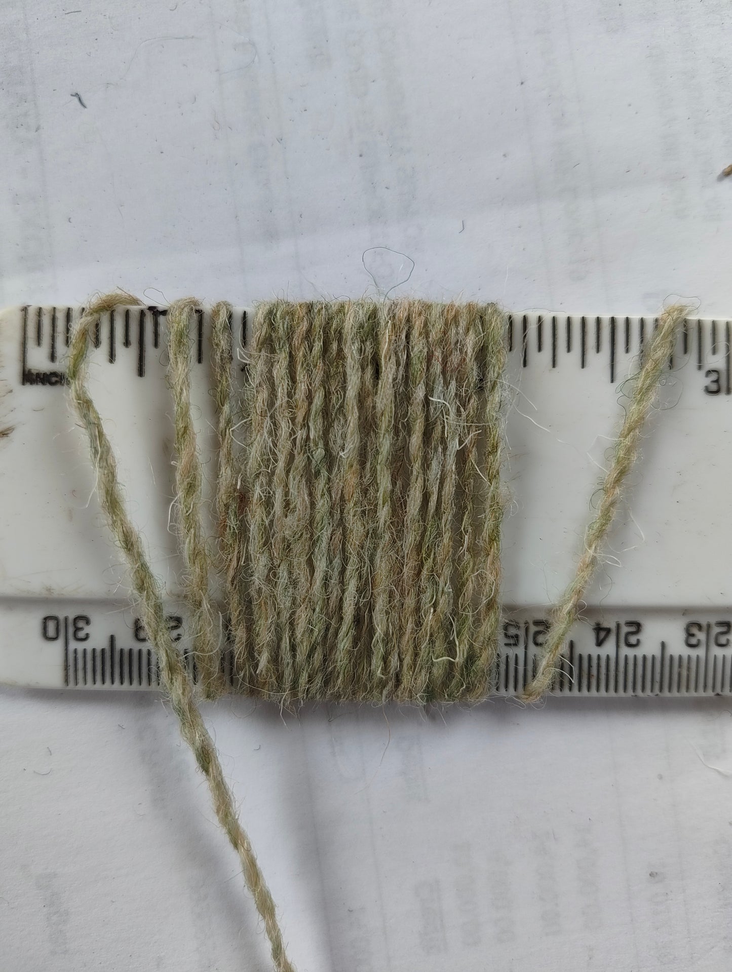 Pale green weaving yarn showing 14 wpi