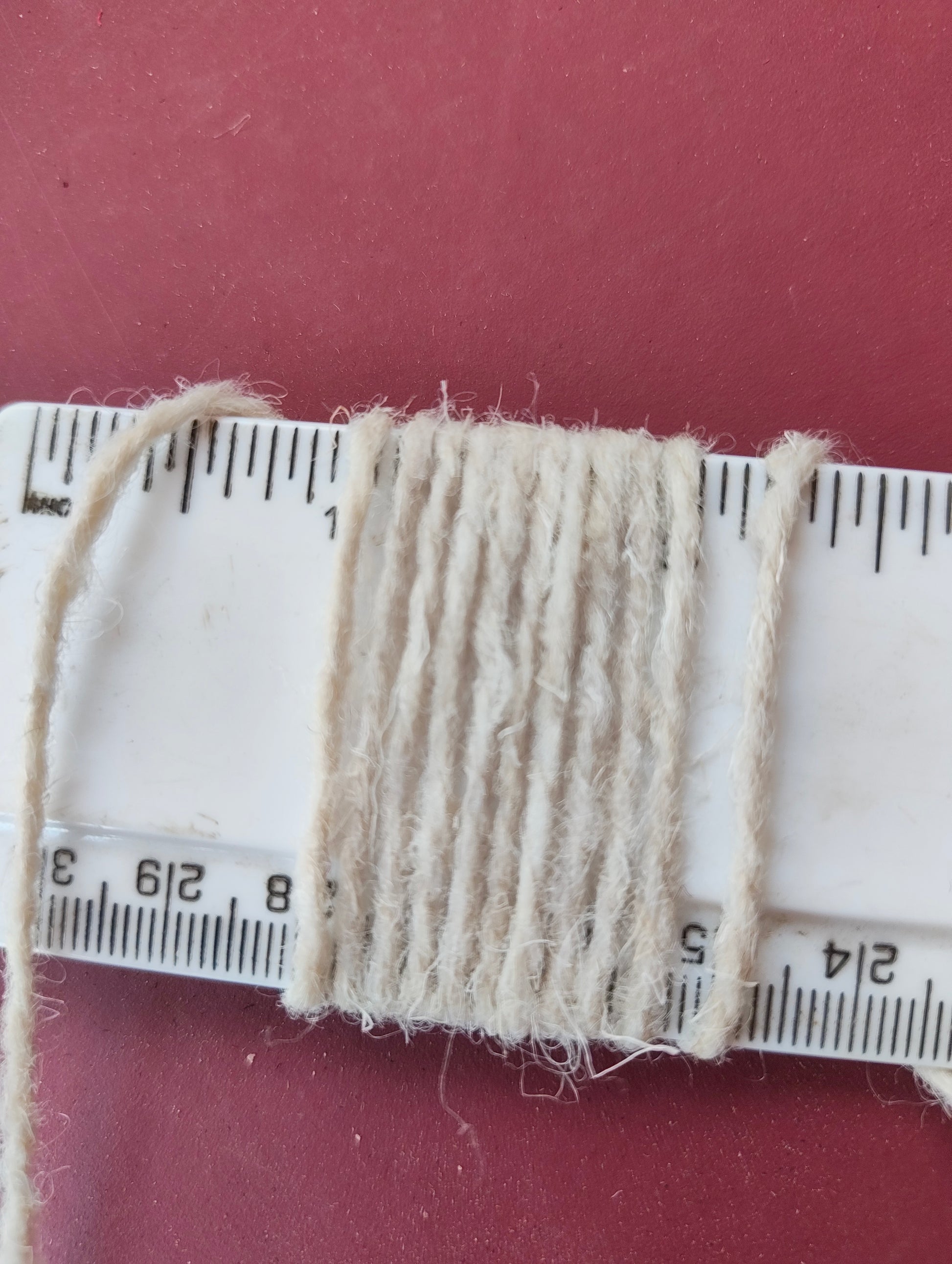 White rug yarn showing 10 wraps per inch