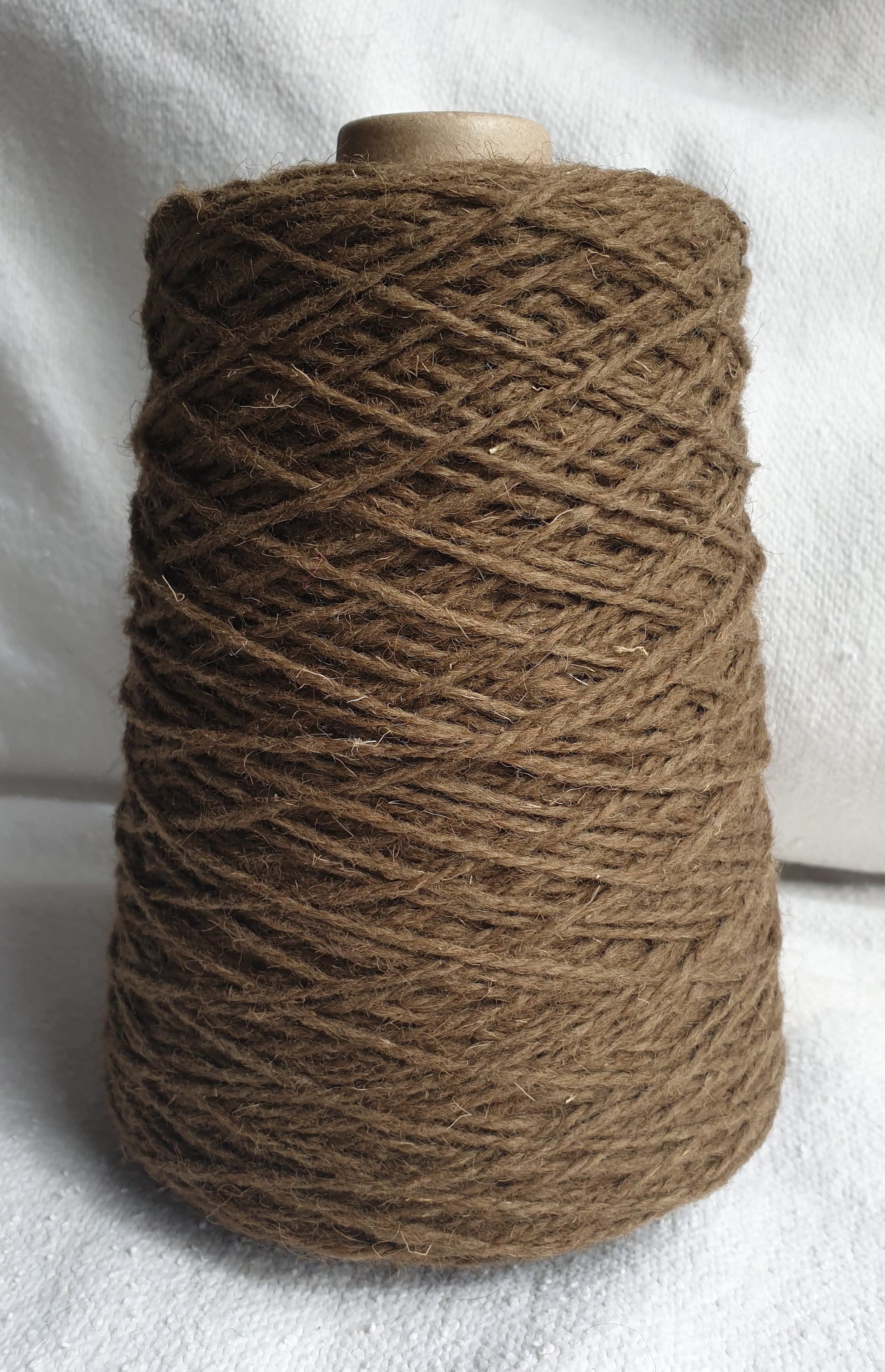 A greenish khaki-ish browny cone of rug yarn