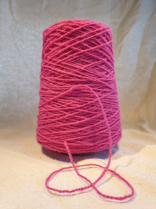 A cone of Cerise Rug Yarn