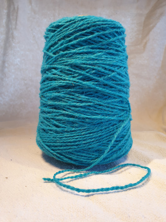 A cone of Light Blue Rug Yarn