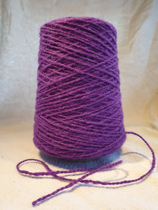 A cone of Purple Rug Yarn
