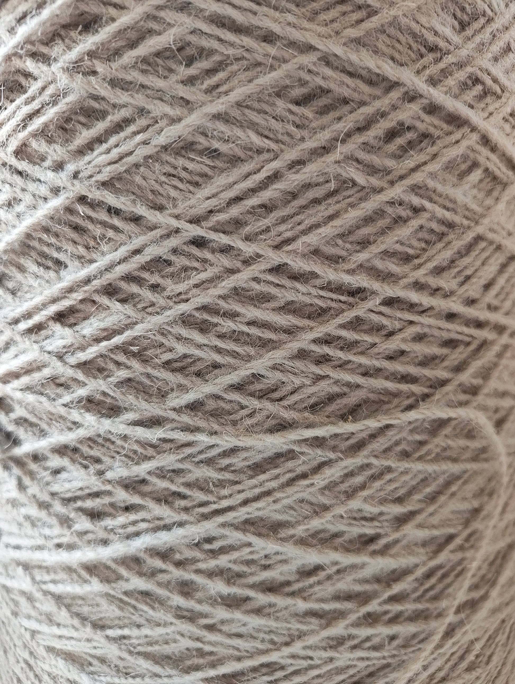 A close-up of grey rug weaving yarn