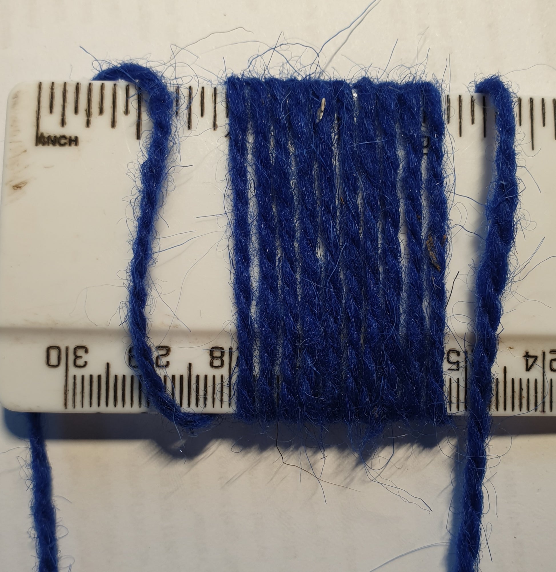 Cobalt blue rug yarn showing wraps per inch