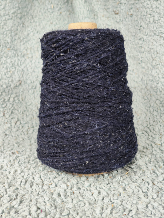 A cone of starlight flecked blue rug yarn