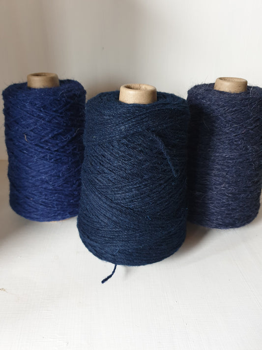 Blue denim coloured rug yarn with blue biro on the left and dark blue on the right