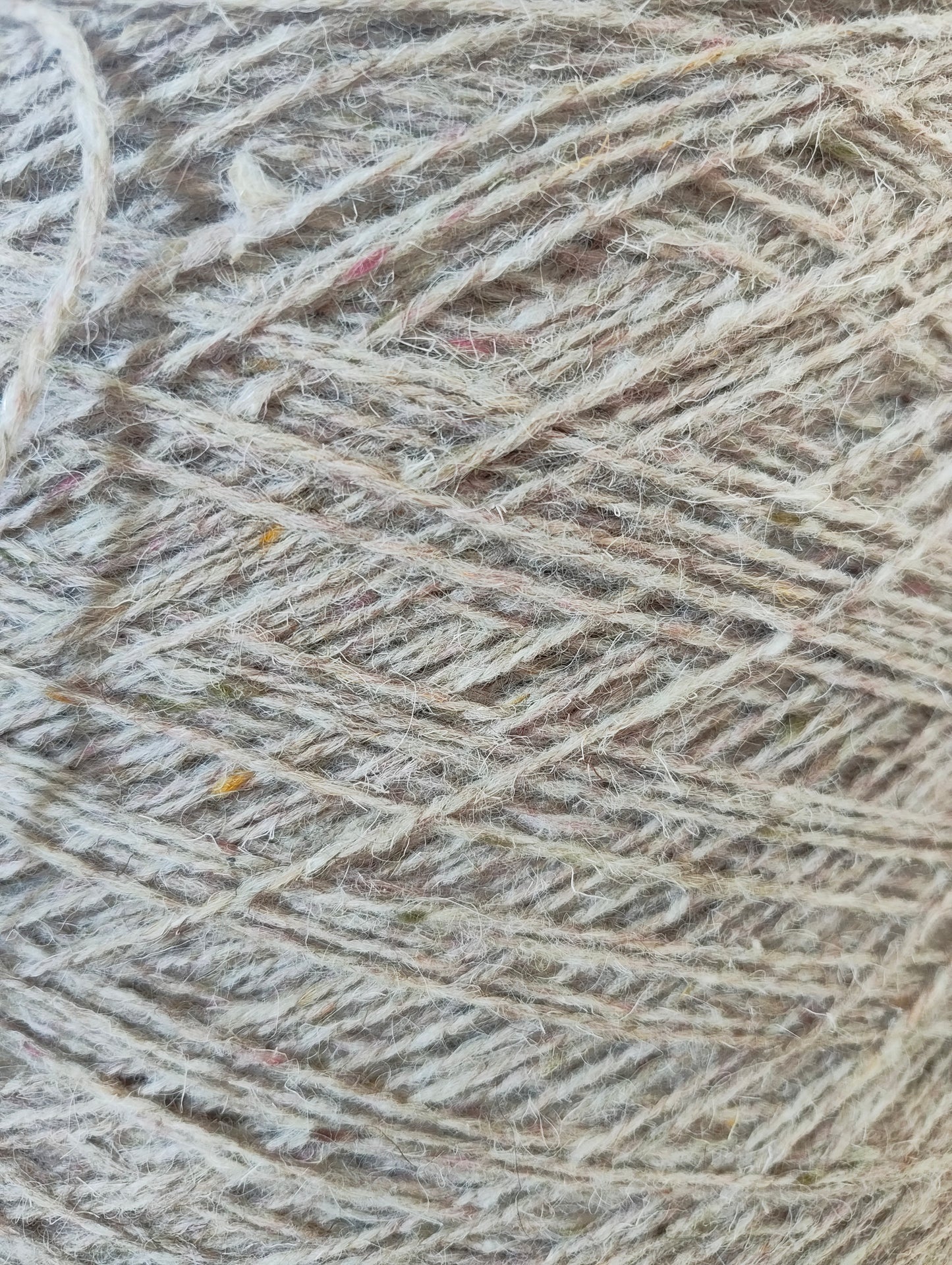 A close-up of pale fawn weaving yarn
showing a warm beige and light brown colour with subtle pink and brown flecks.