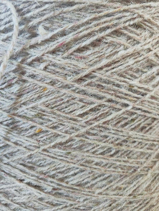 A close-up of pale fawn weaving yarn
showing a warm beige and light brown colour with subtle pink and brown flecks.