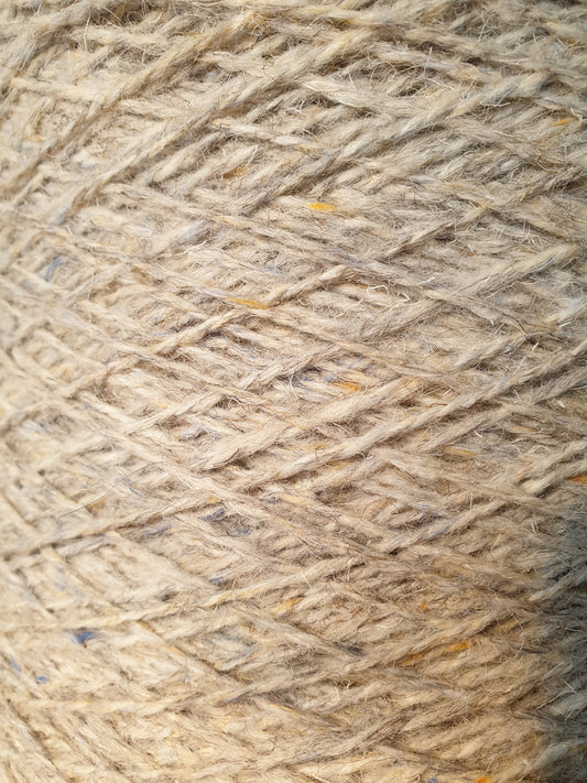 Close up of a light grey speckley rug showing some blue and yellow flecks