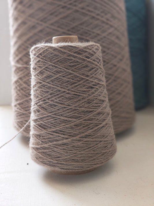 A cone of grey rug weaving yarn