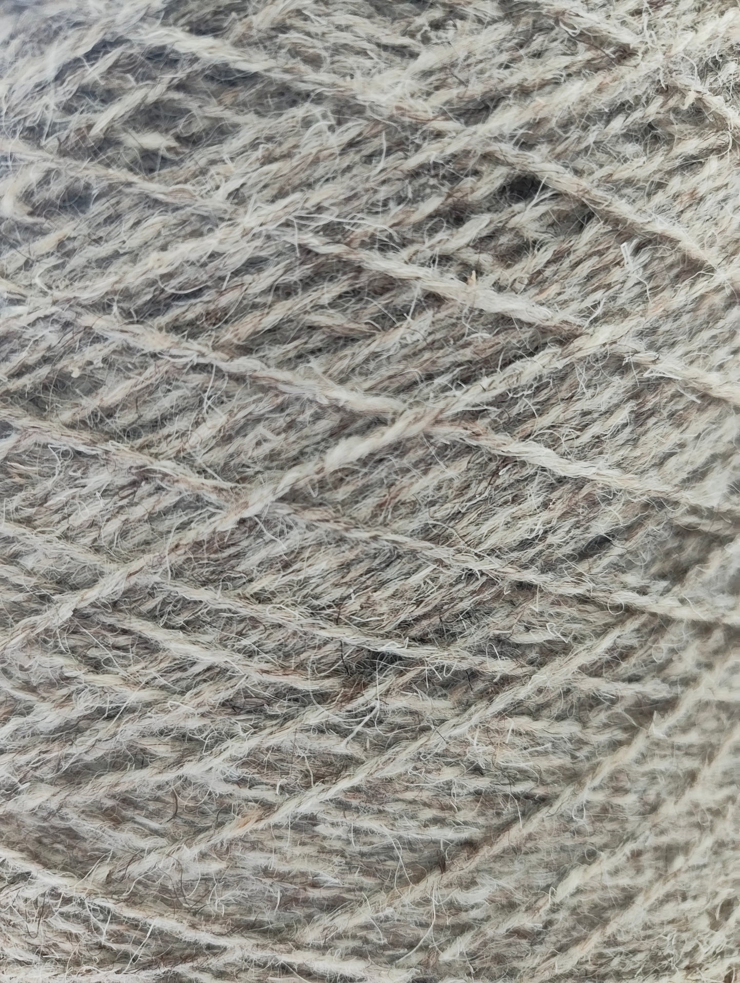 A close-up of tweedy grey rug yarn with a heathered blend of grey fibres.