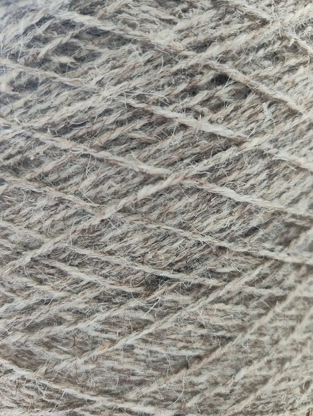 A close-up of tweedy grey rug yarn with a heathered blend of grey fibres.