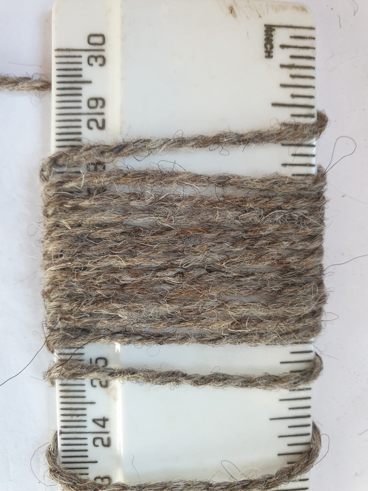 grey Rug yarn showing wraps per inch