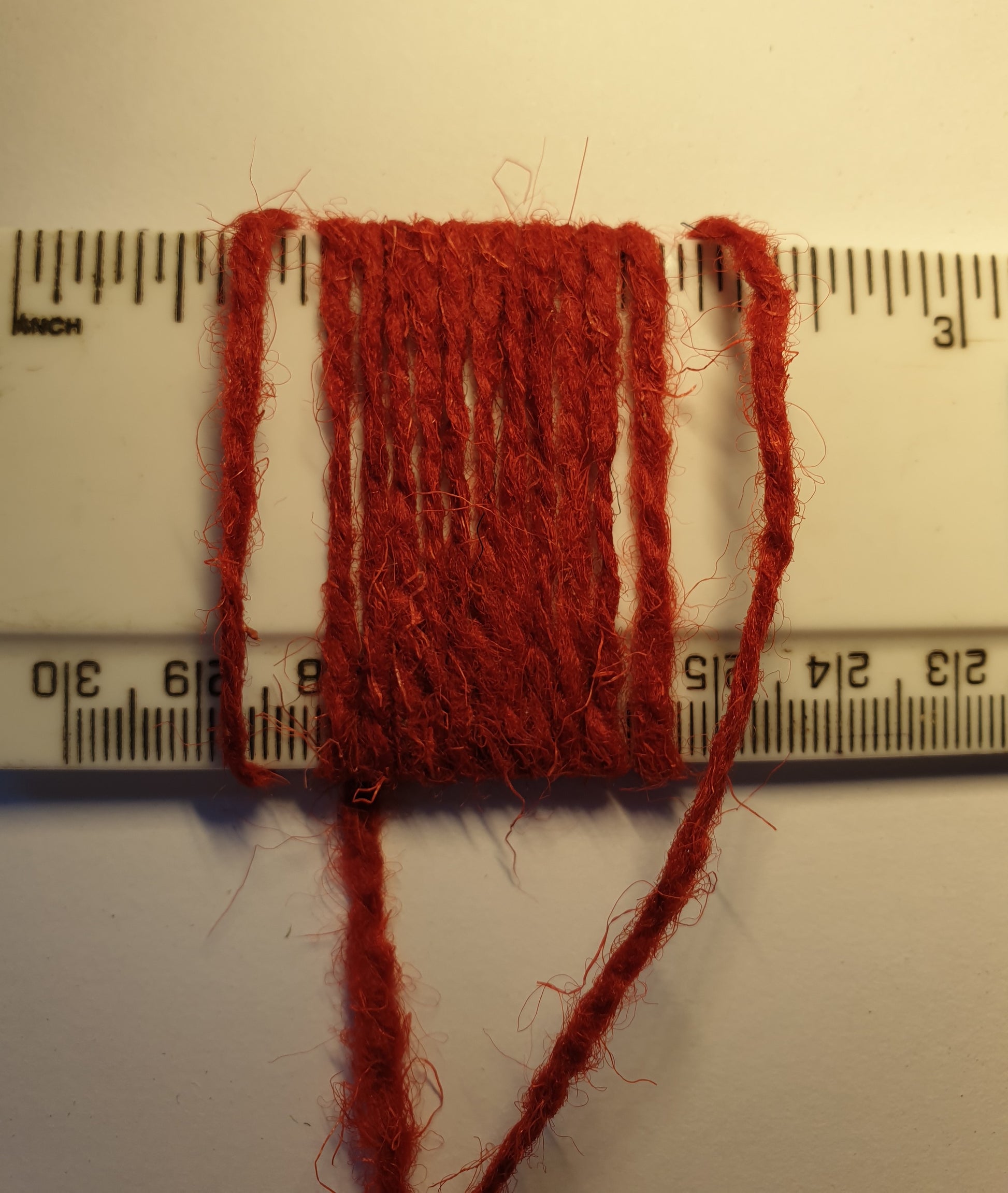 Tomato red yarn showing wraps per inch