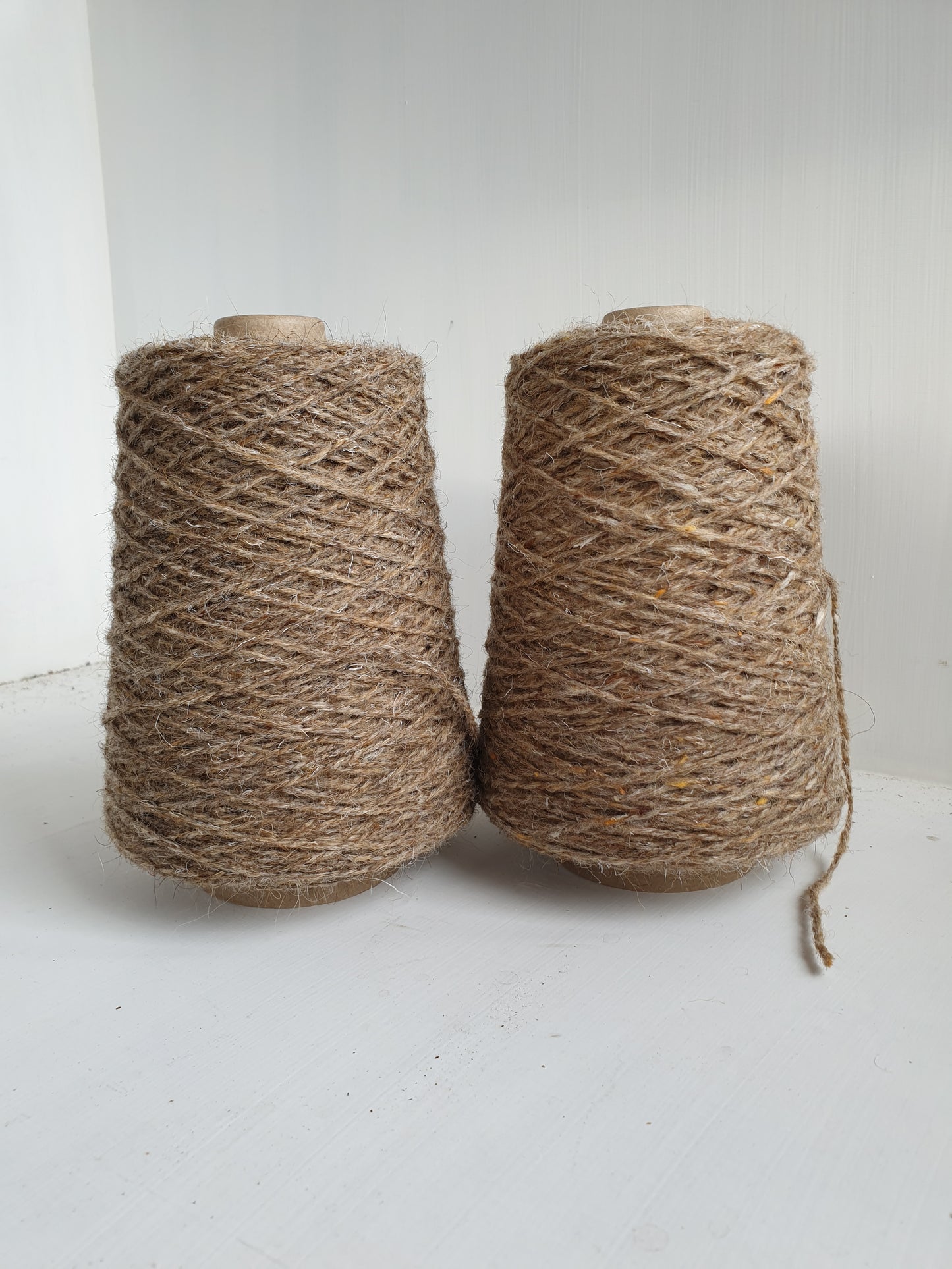 2 slightly different cones of fawn tweed rug yarn